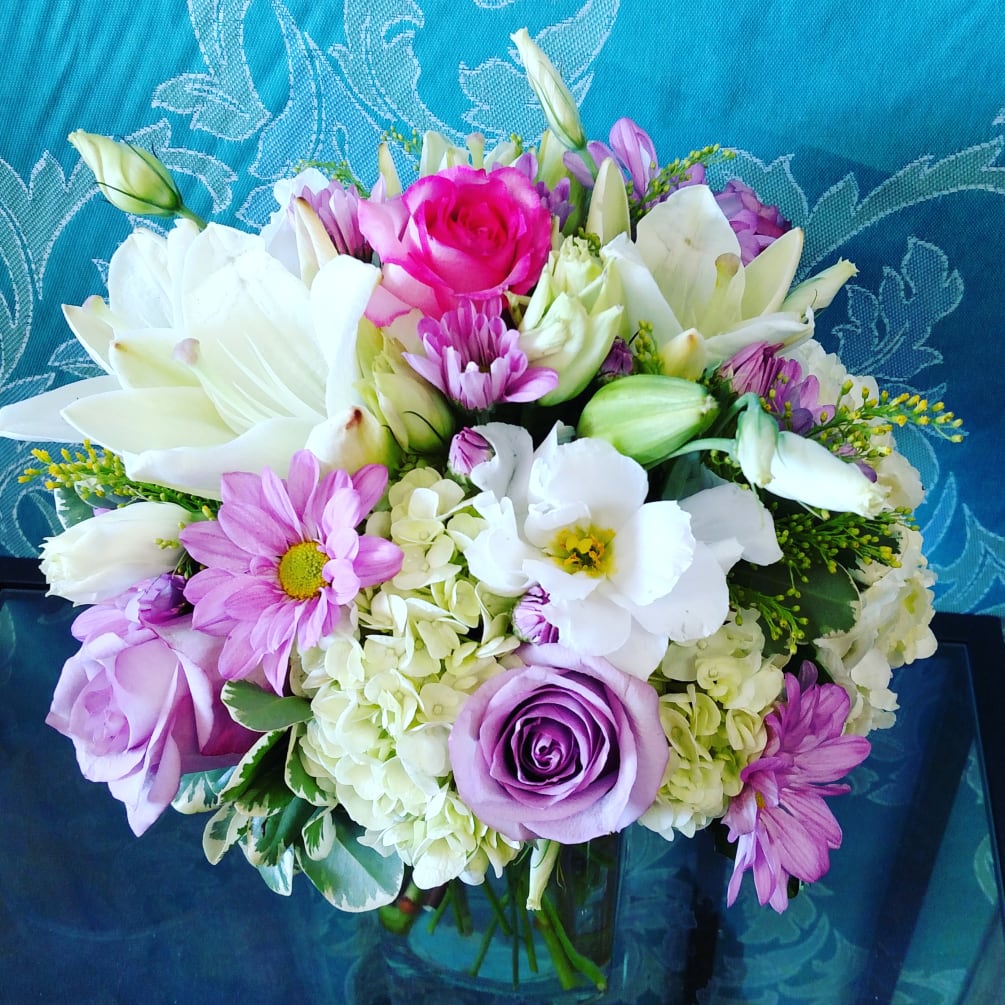Lilac roses, daisies, and hydrangea, with complimenting lilies and filler flowers in