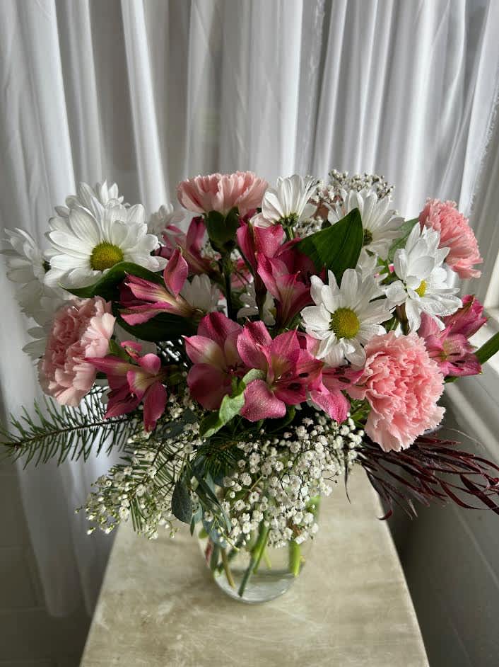 Alstro, babies breath, carnations, and more tie this cute romantic arrangment together.