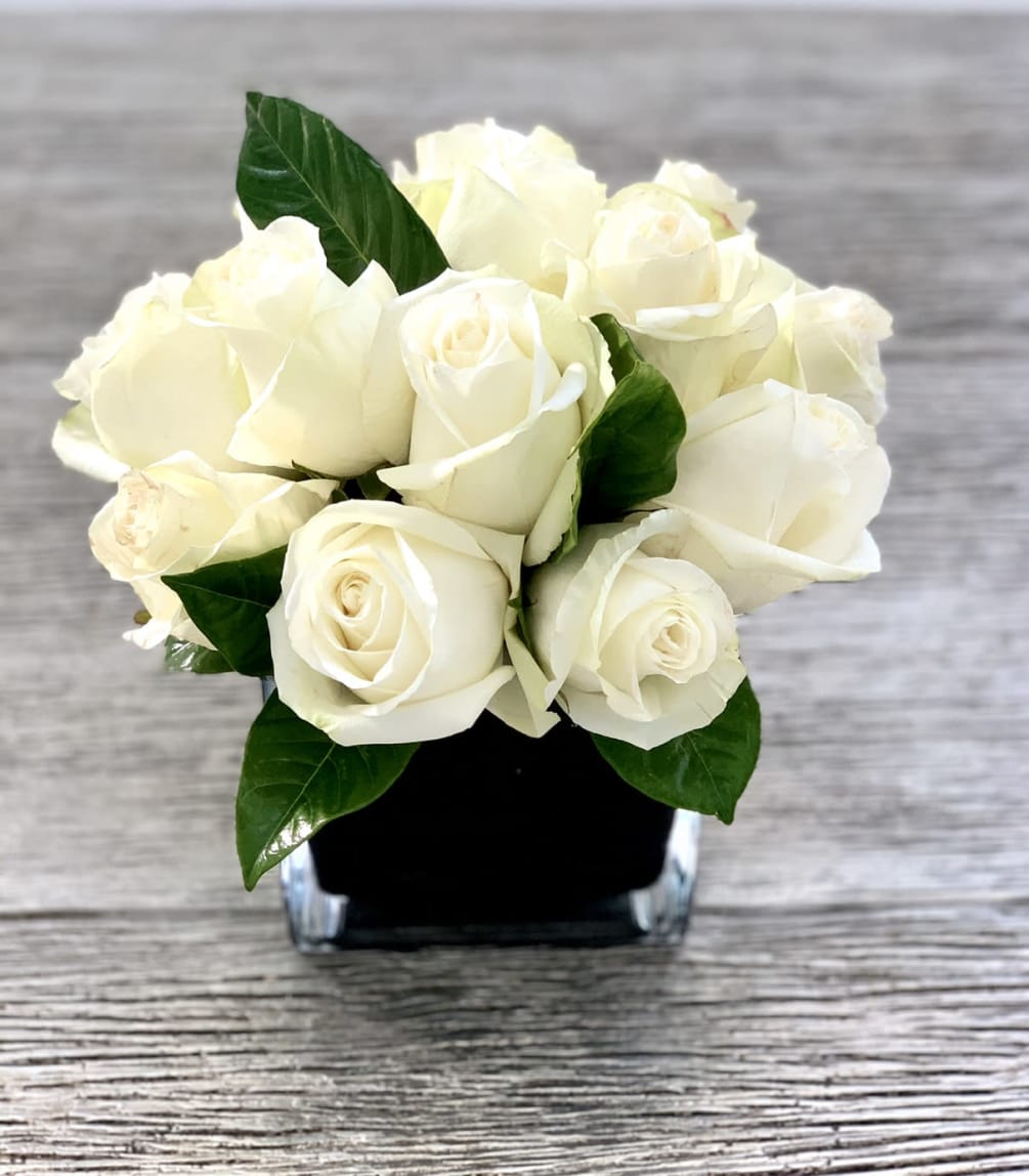 Dozen white roses in a glass cube vase