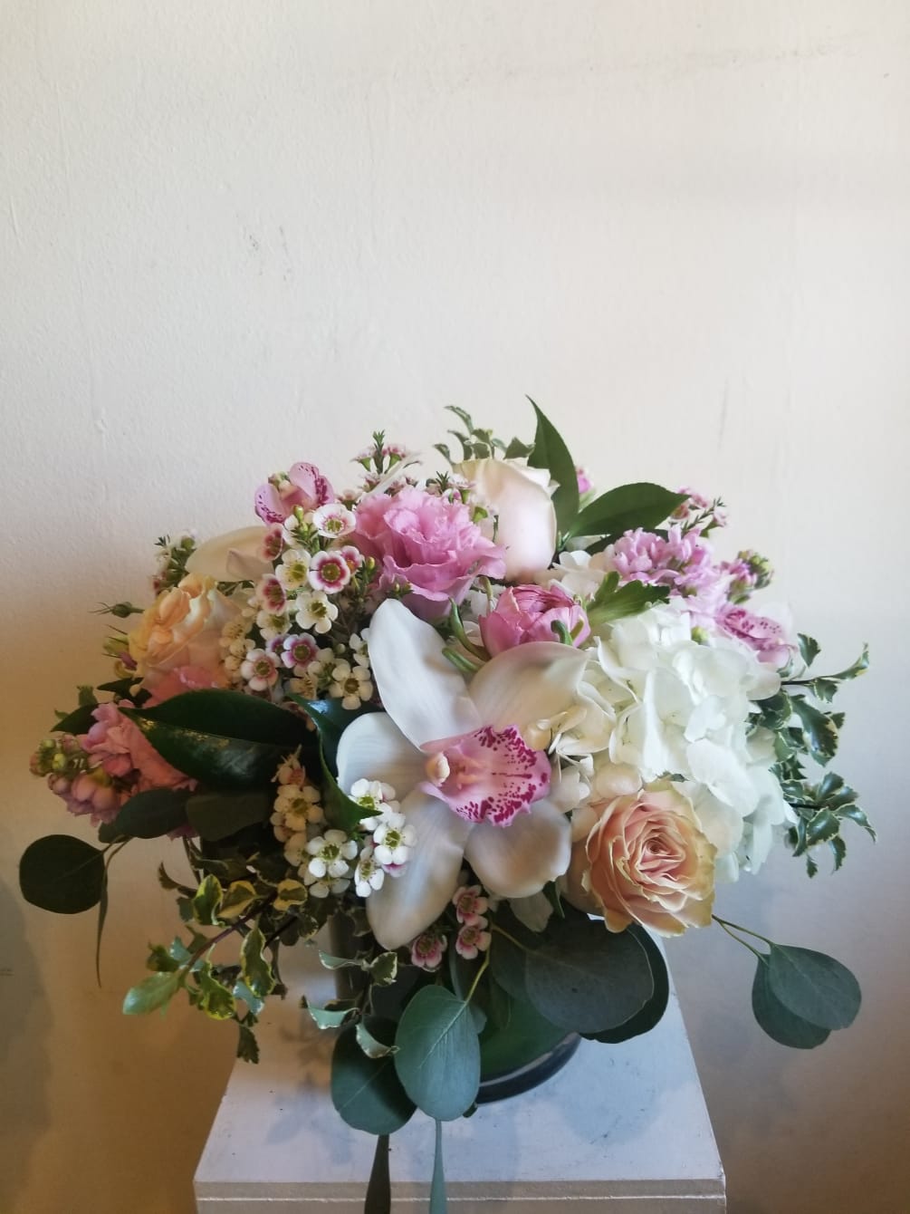 Beautiful mixture of white and pink including, roses, hydrangea, orchids, and complimentary