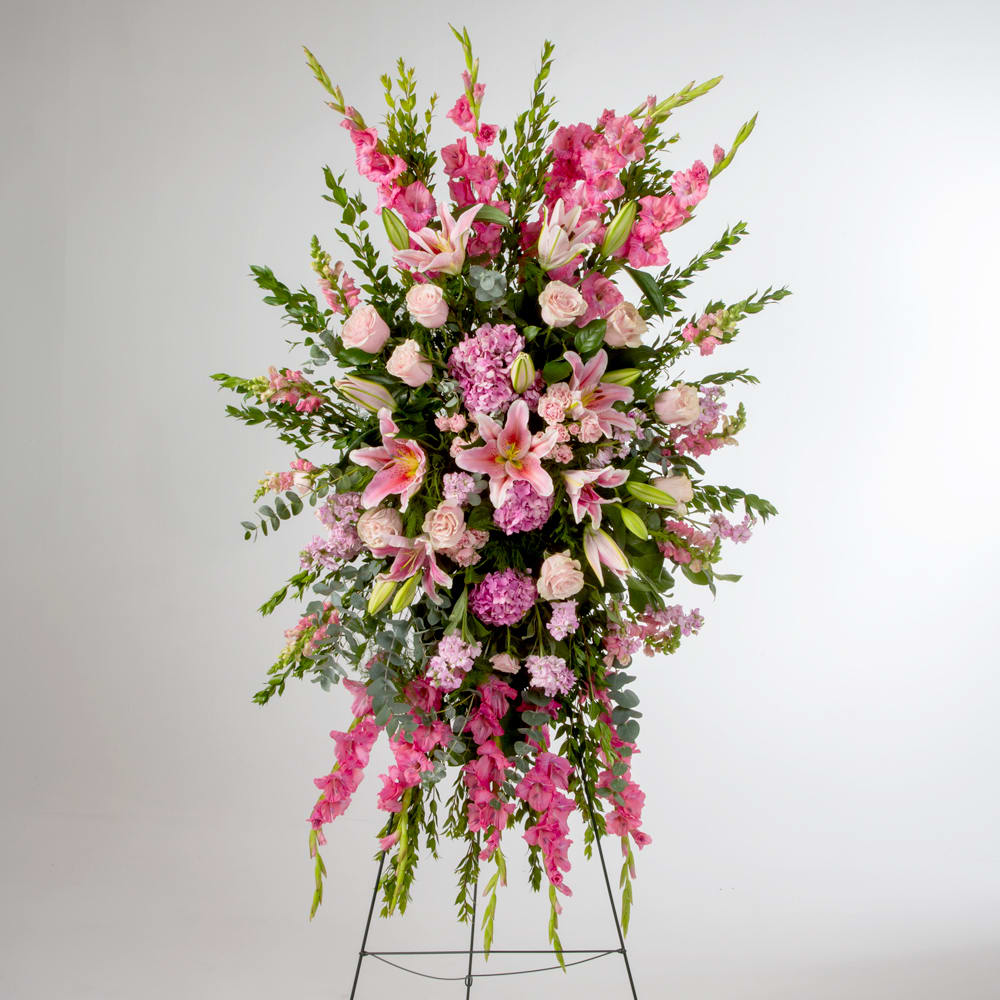 Pink roses, lilies, and more come together for a blushing pink standing