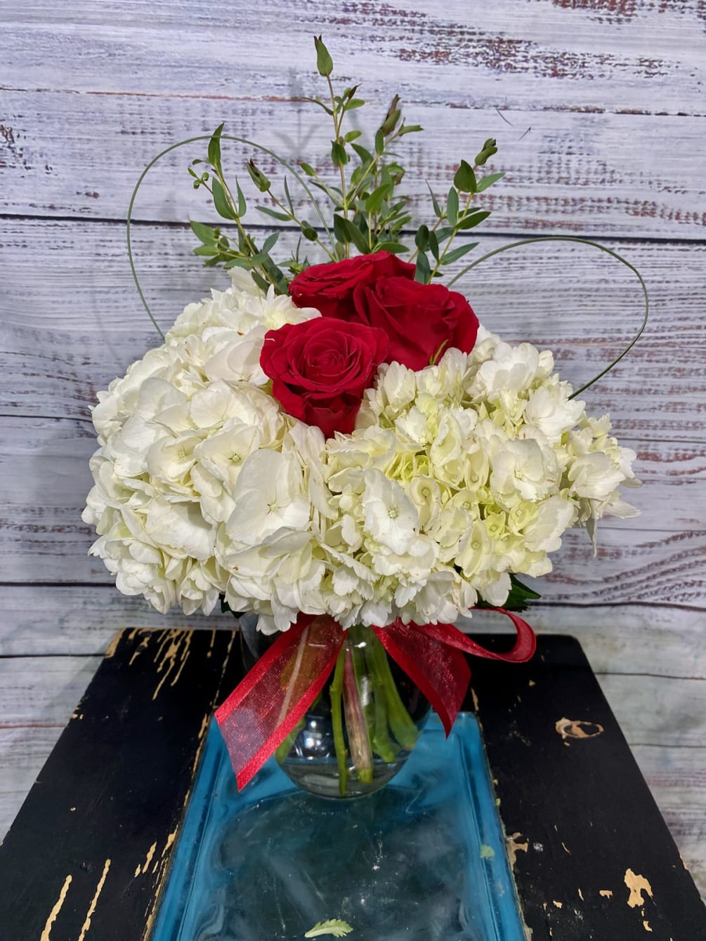 Beautiful white hydrangeas embracing red roses with heart