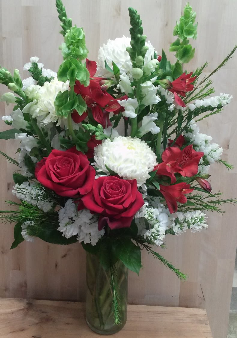 This red and white bouquet is designed with mums, roses, snapdragon, bells