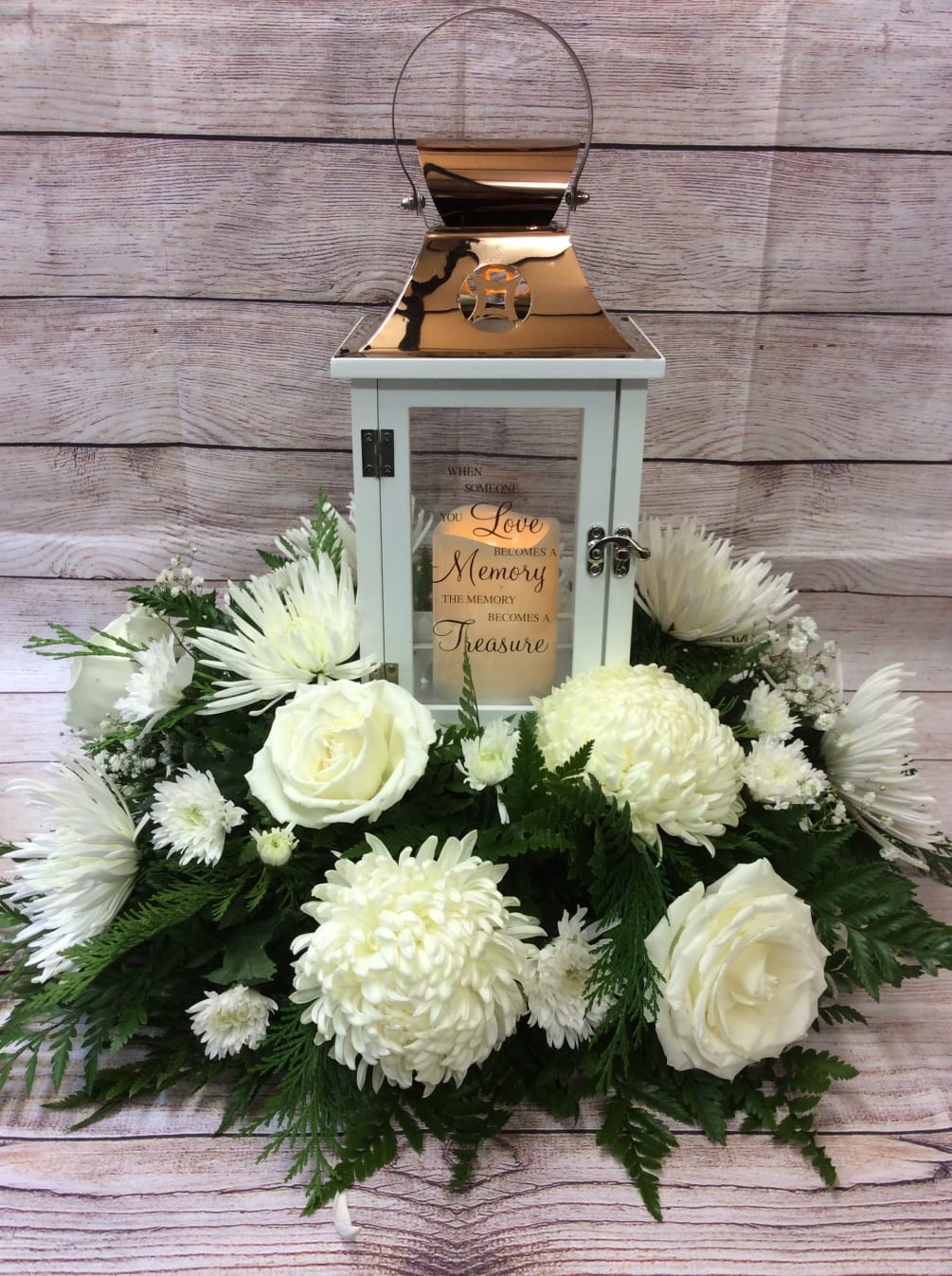 All white blooms surrounding a beautiful keepsake lantern with varying sentiments. All
