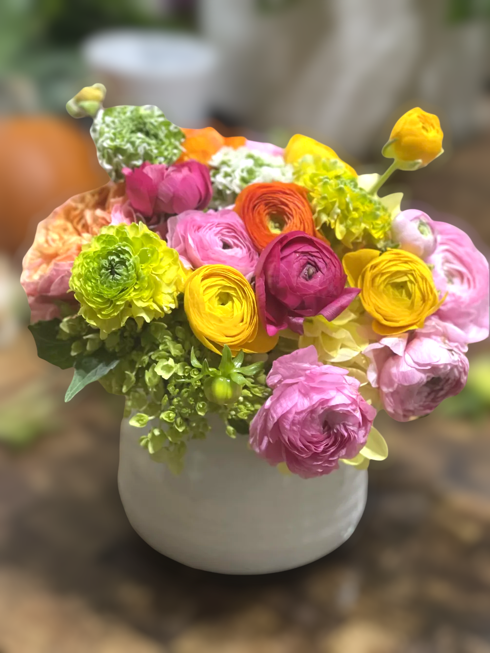 A high quality ceramic vase filled with dainty ranunculus and other specialty