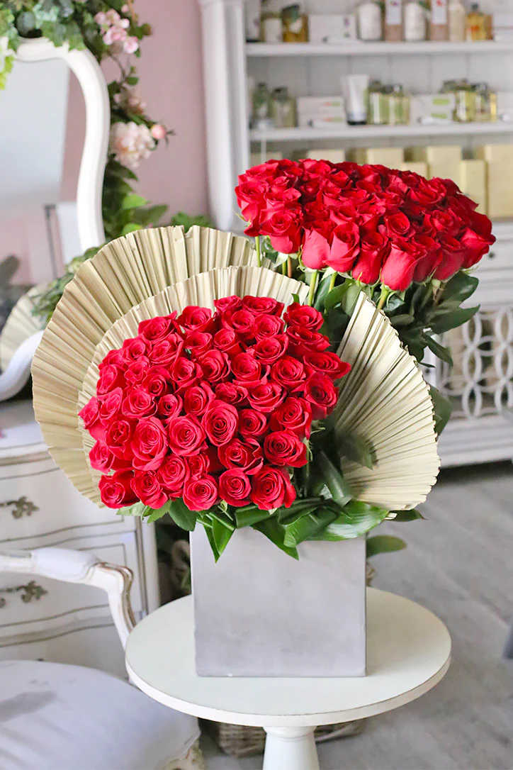 A spell-binding flower arrangement featuring two breathtaking bouquets of passionately red roses
