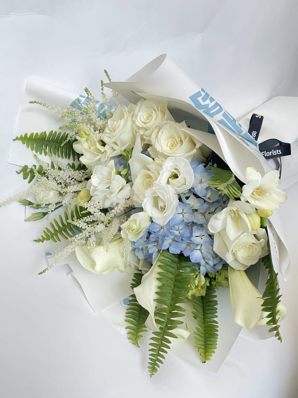 This bouquet features white and soft blue colors. 