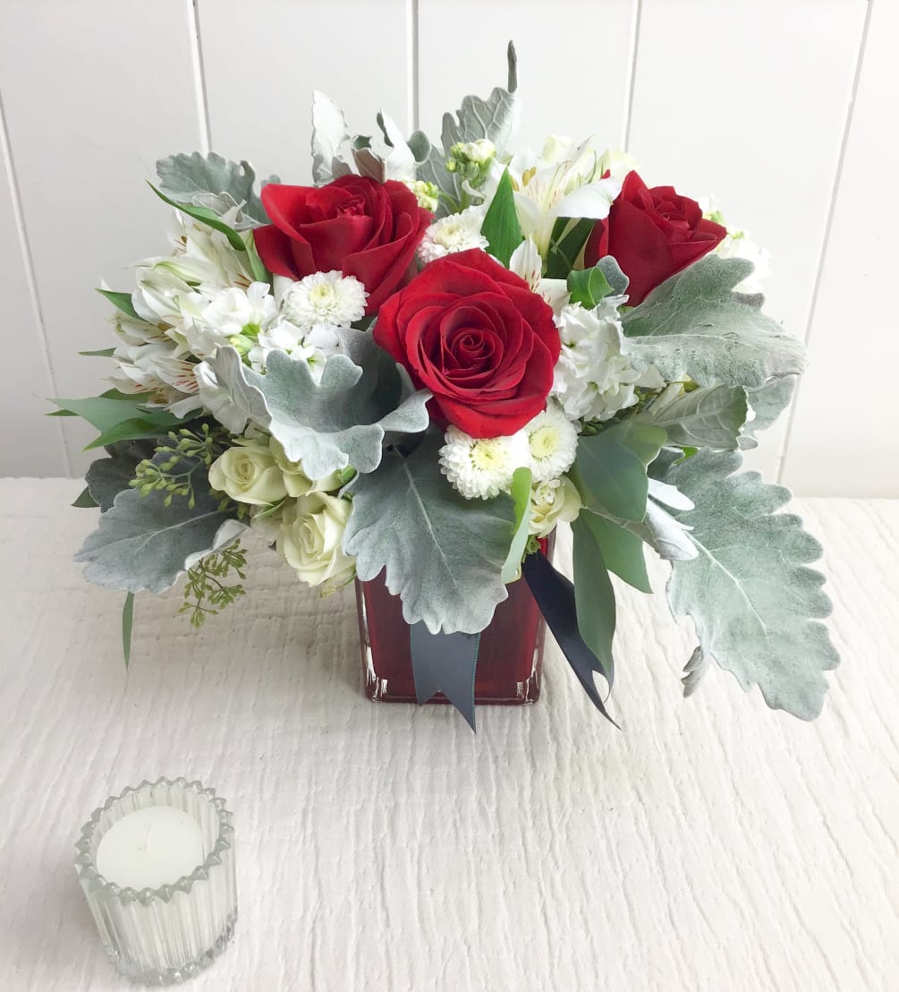  Deep vivid roses, white stock, and gray dusty miller are expertly