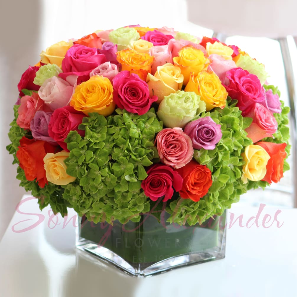 A bright, cheerful, and lovely arrangement of candy-colored roses mixed with crisp