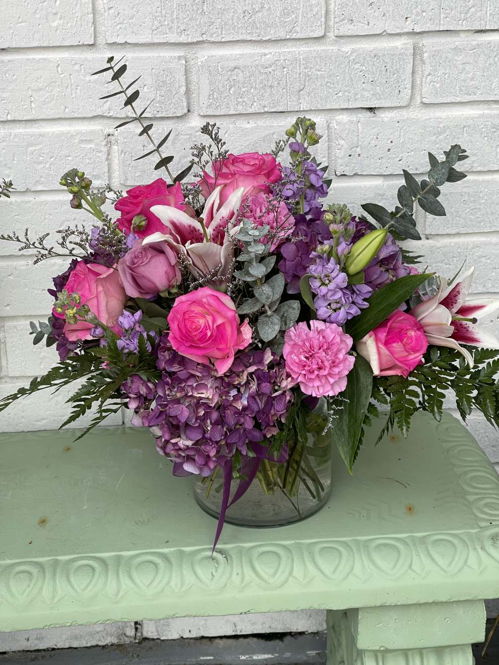 a beautiful floral arrangement created with a european vase with a mixture
