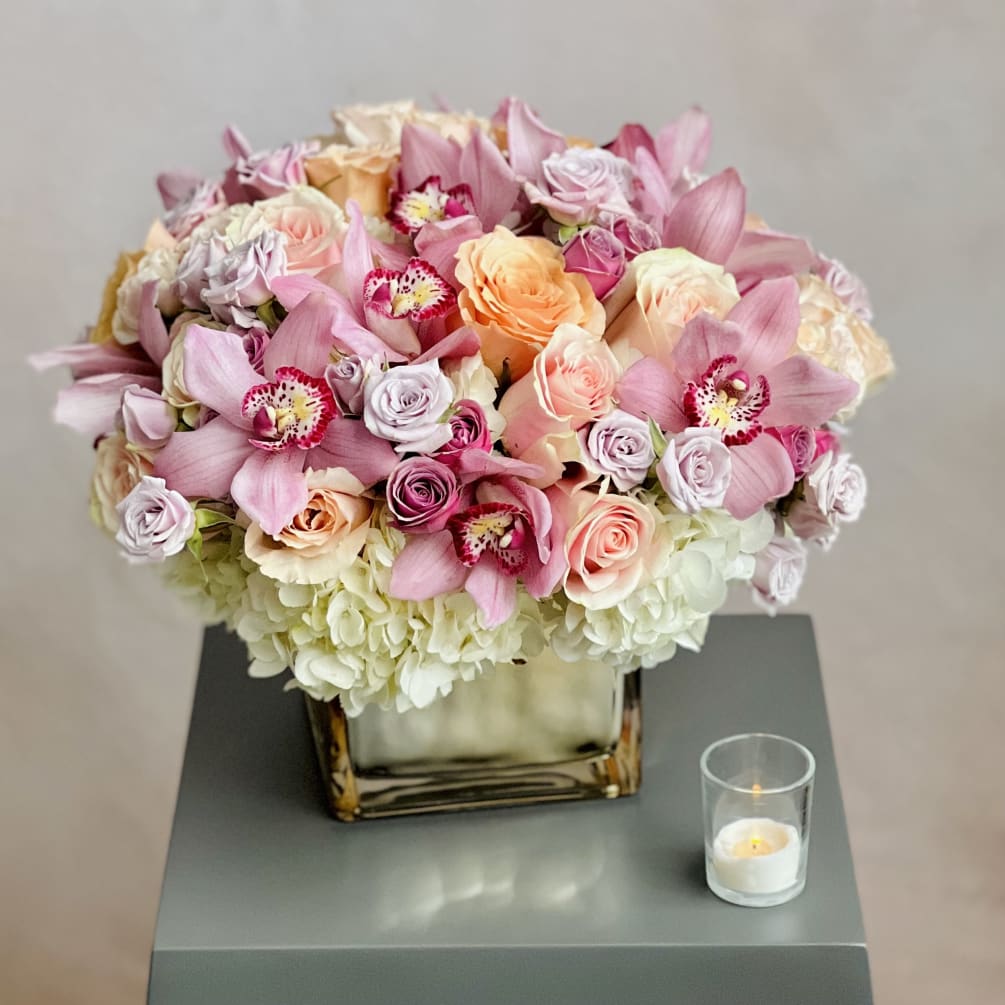 A beautiful arrangement made with Spray Roses, Pink Cymbidiums, Hydrangeas and Peach
