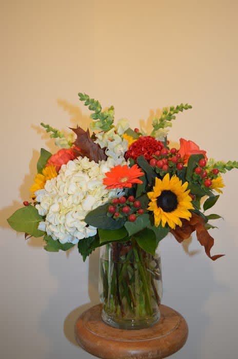 Beautiful mix of seasonal white hydrangea, sunflowers, orange gerber daisy, snap dragon