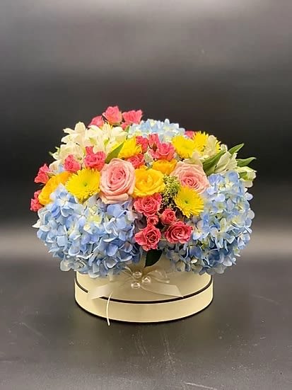 Flower mix with hydrangea and roses in a hat box ( we