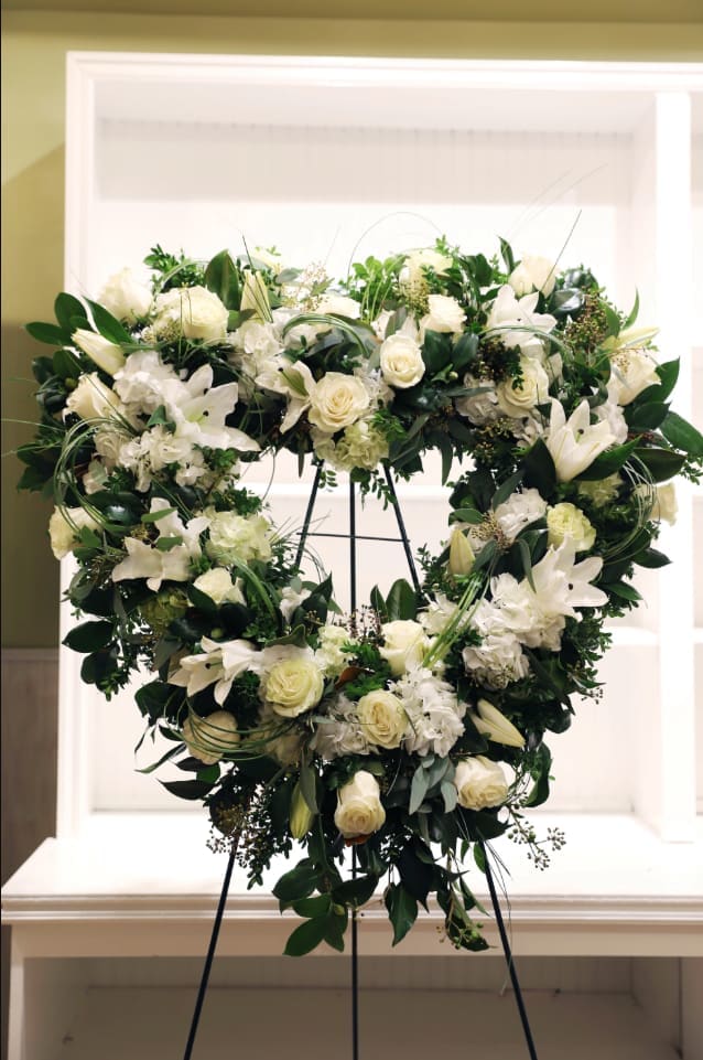 All white flowers including roses and orchids in an open heart