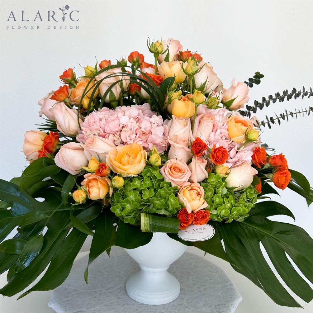 A beautiful modern arrangement of baby roses, hydrangeas, lisianthus and more in