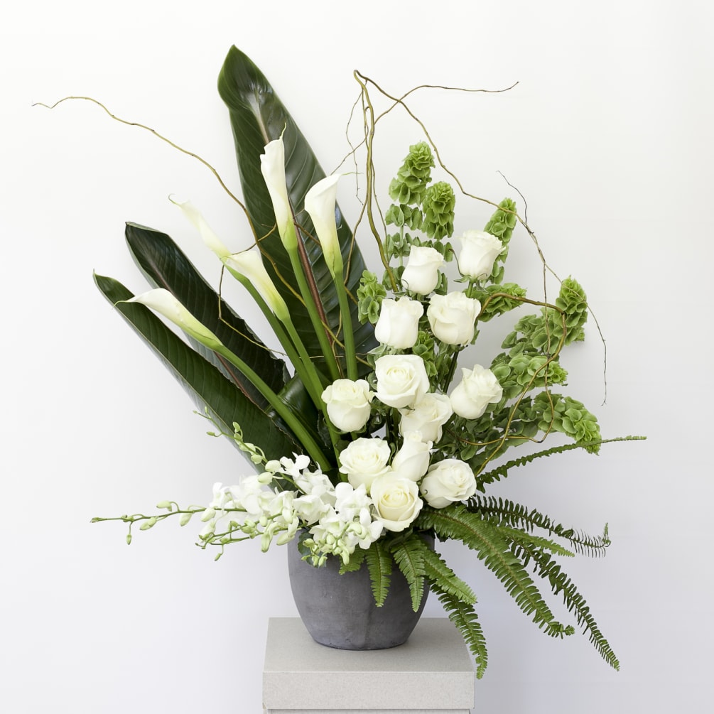This stylish and elegant arrangement includes white roses and large calla lilies