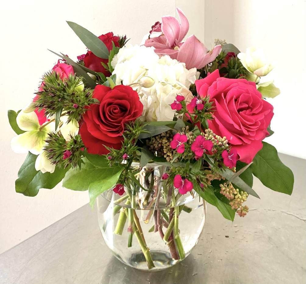 Arrangement with hot pink and red roses, fuchsia dianthus and other flowers