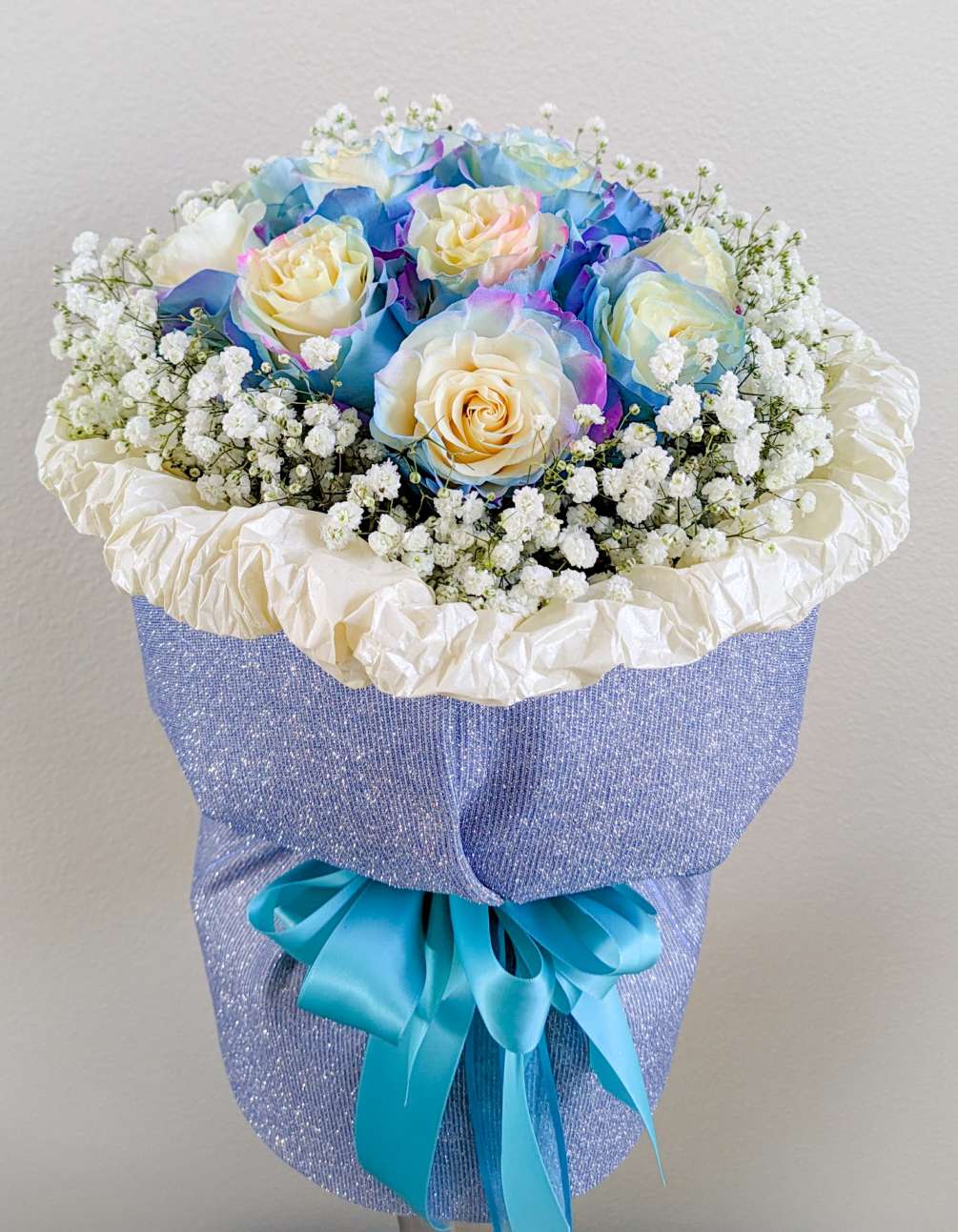 1 dz. Aurora-multi color roses surrounded by baby&#039;s breath, arranged in a