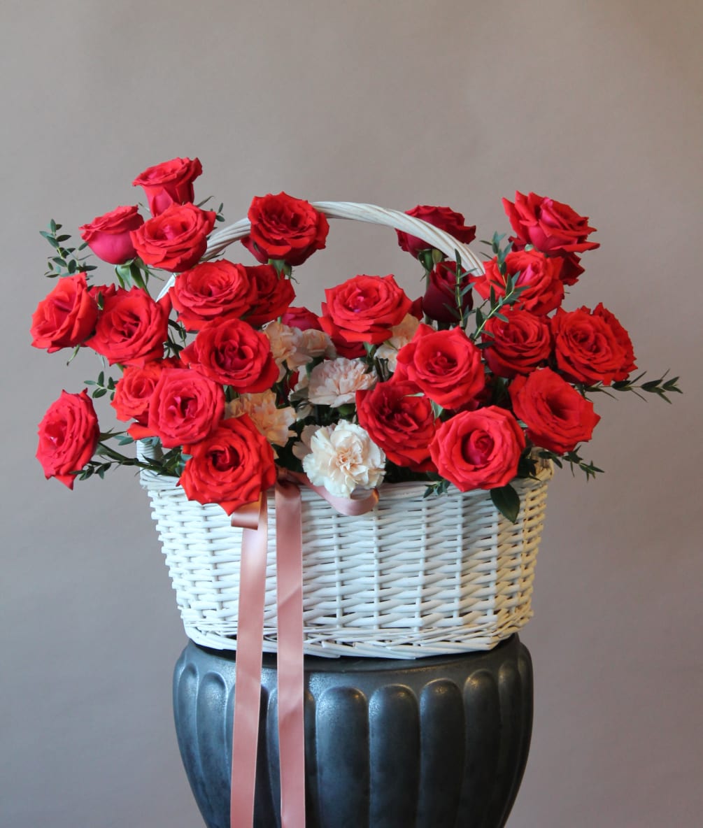 Basket with red roses and peach carnations. 
Standard version contents 30 roses