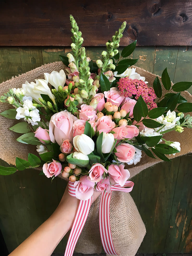 Bright pink, coral, and peach flower bouquet wrapped with burlap and coral