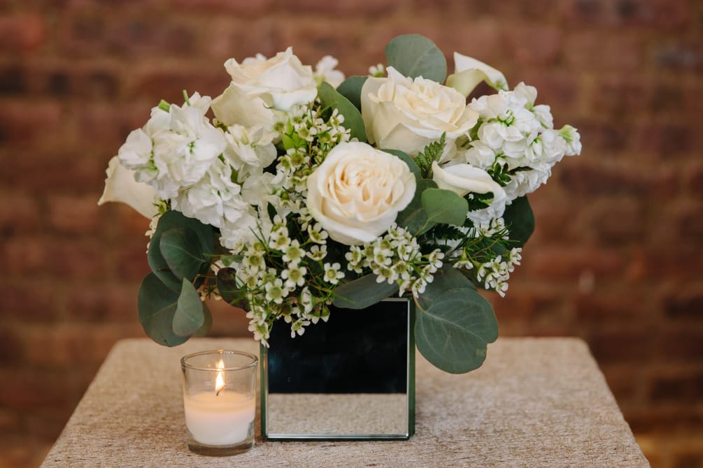 An elegant arrangement of all white seasonal floral blooms designed in a