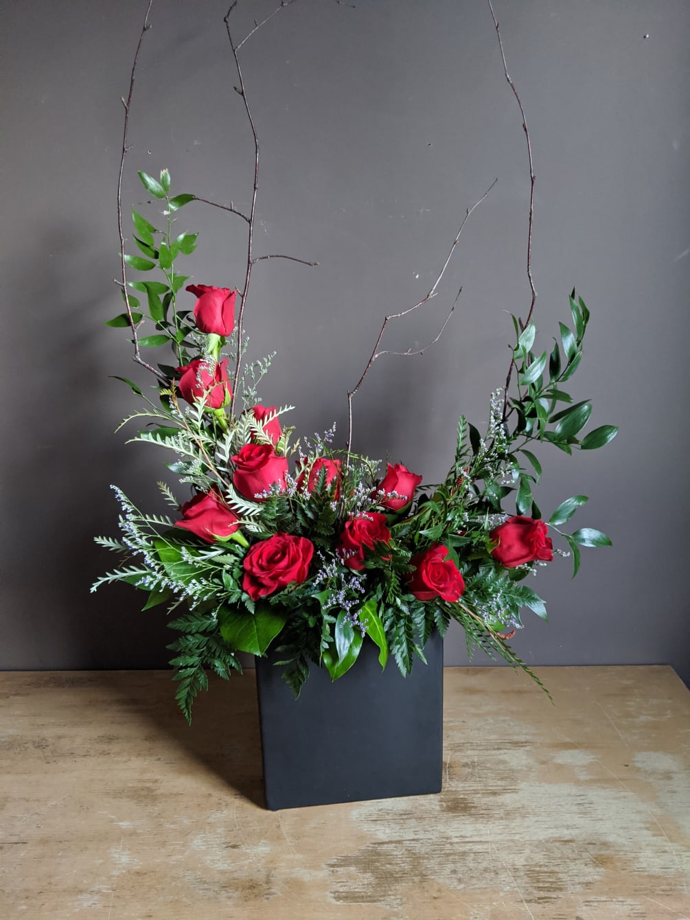A modern twist on one dozen red roses in a sleek ceramic