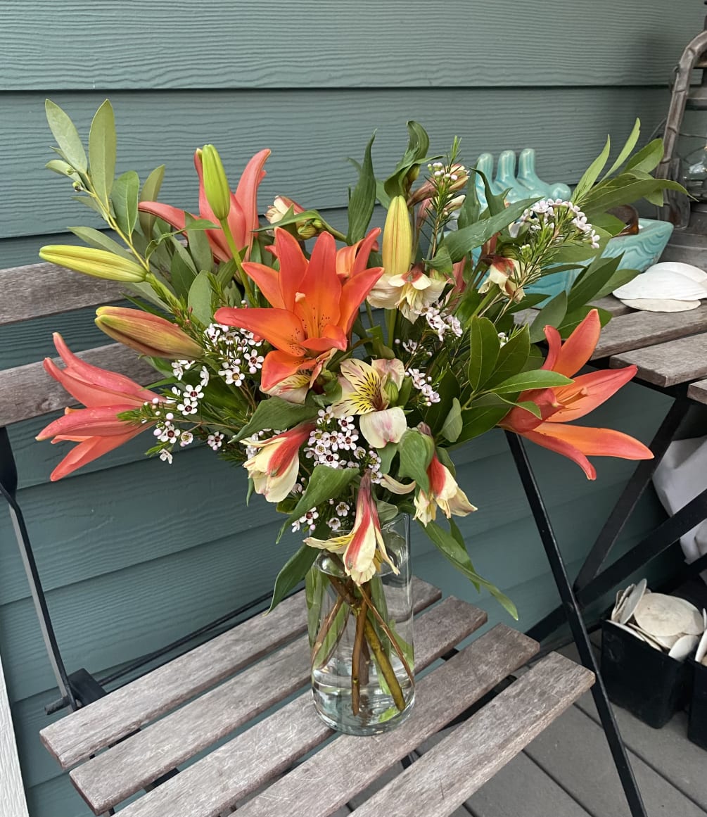 A simple yet powerful arrangement with bright orange lilies and white filler