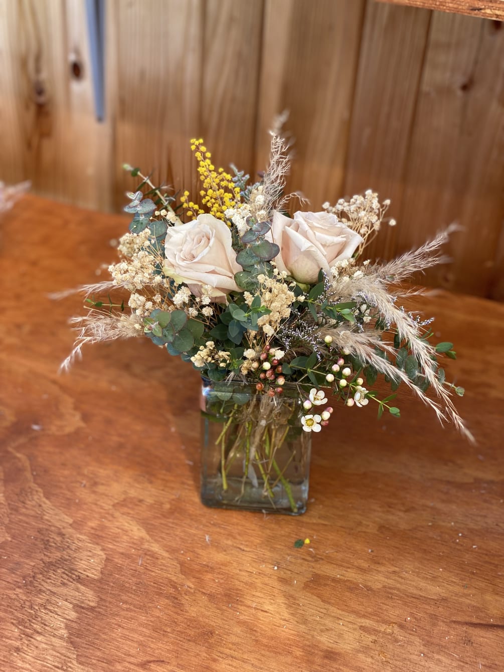 A natural arrangement look with dried pampas, fresh roses, spray roses, sprays