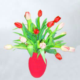 Assorted tulips arranged in a red vase accented with a ribbon or