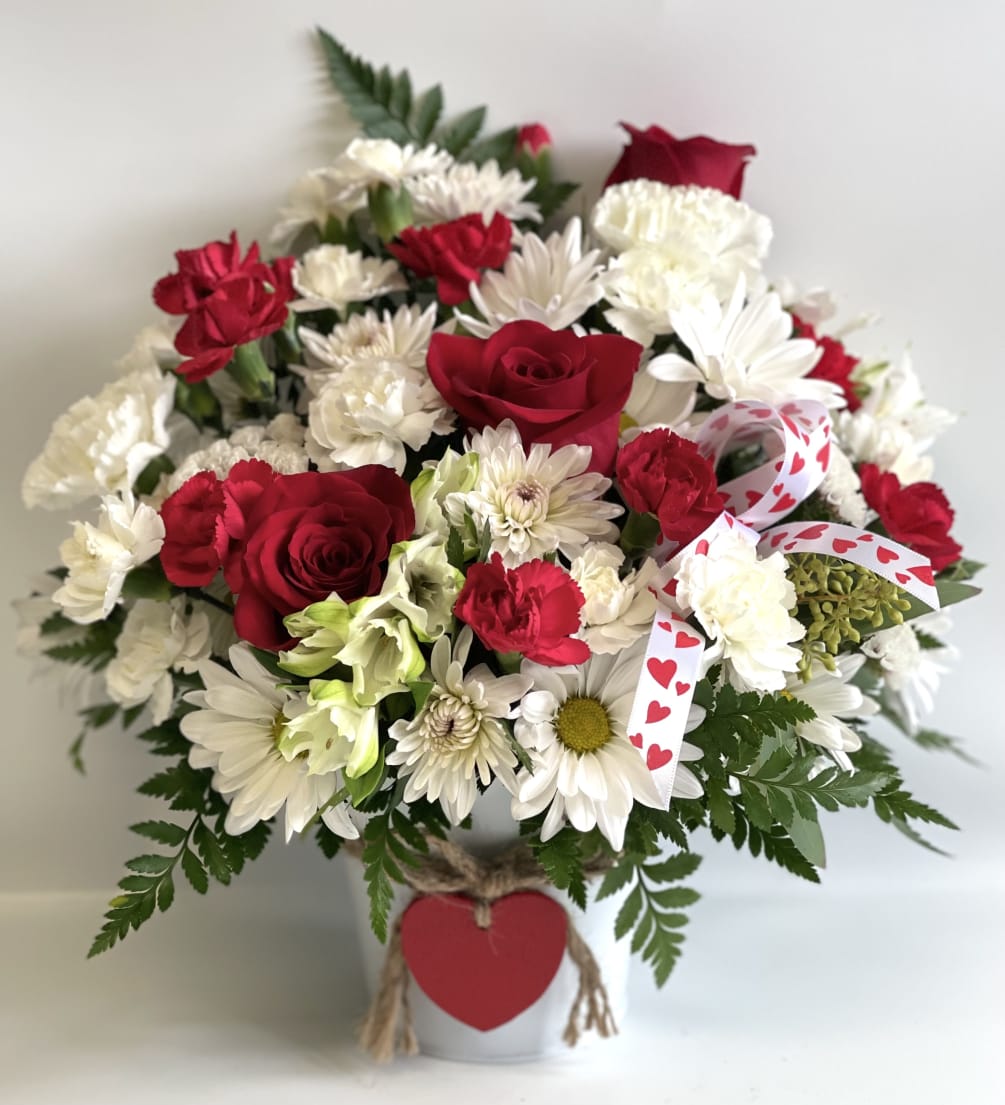 This large metal bucket is filled with a traditional design bouquet. Has