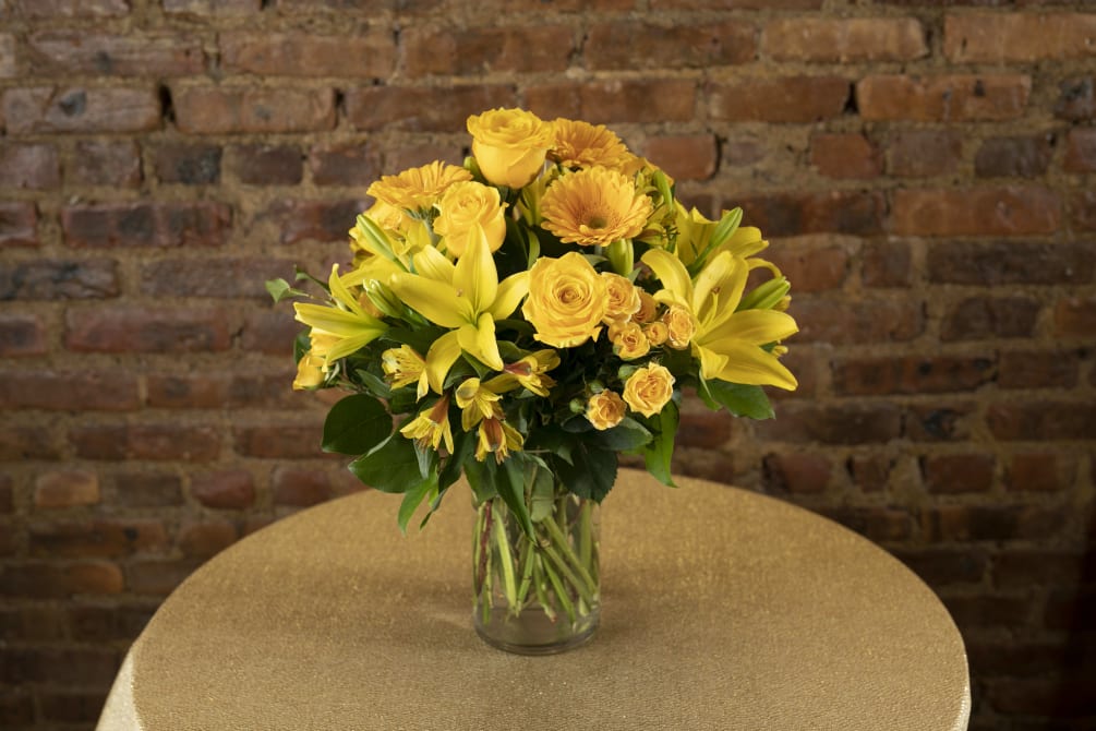 A gorgeous display of golden yellow seasonal floral blooms designed in a