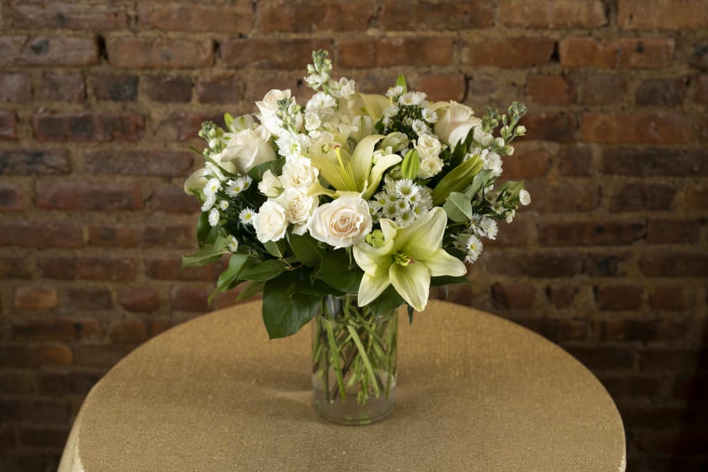 A gorgeous display of lush white and creme seasonal floral blooms designed