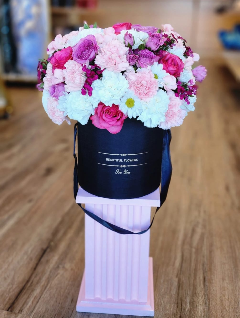A wonderful cylindrical box filled with flowers for that special person in