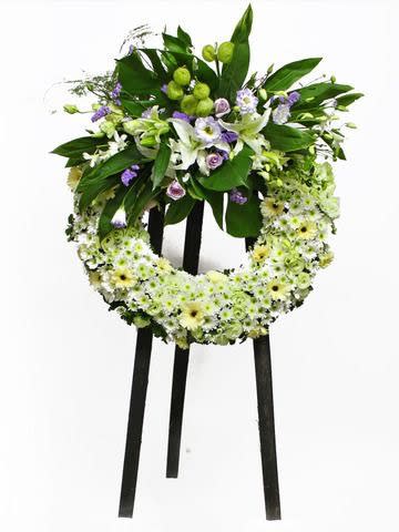 Classic funeral design with tropical greenery and a touch of  daisy
