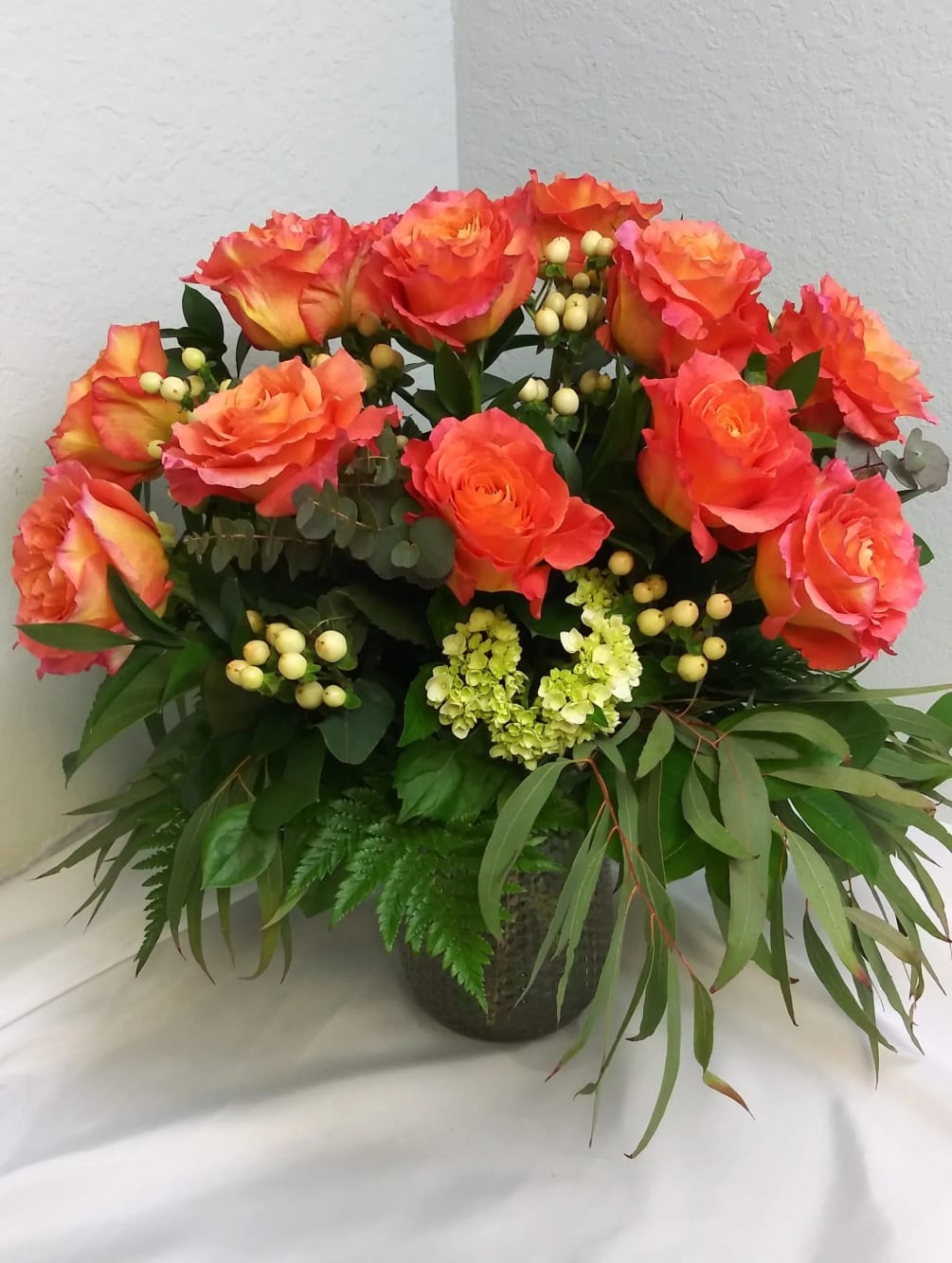 One dozen beautiful orange roses with greenery and fillers.