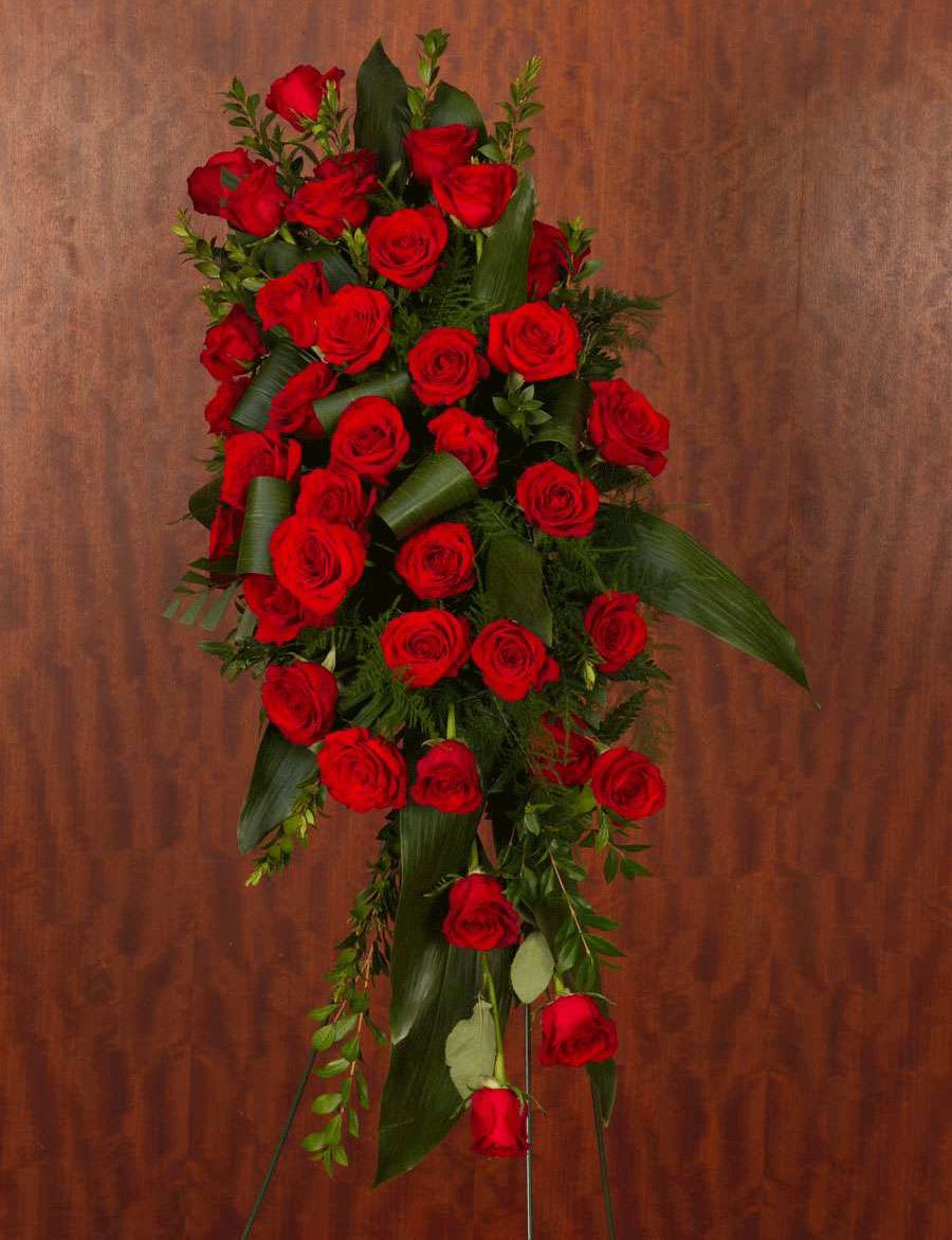 Standing spray of red roses and greenery. Greenery based on availability.