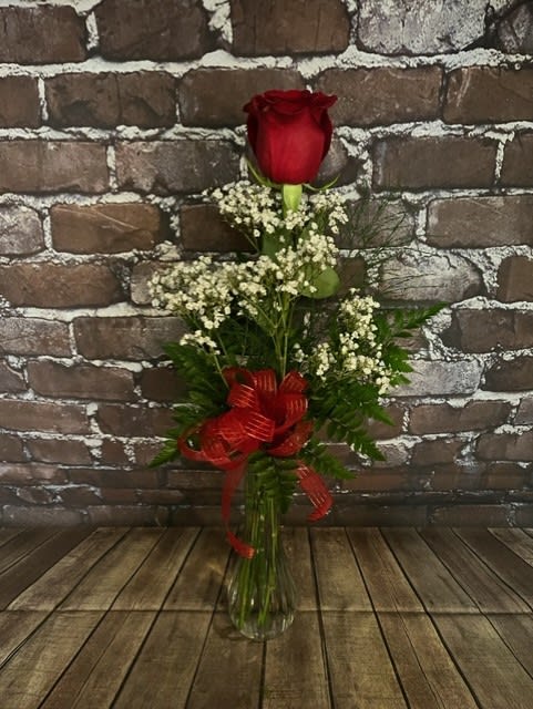 A single red rose in a glass bud vase.  Simple, but