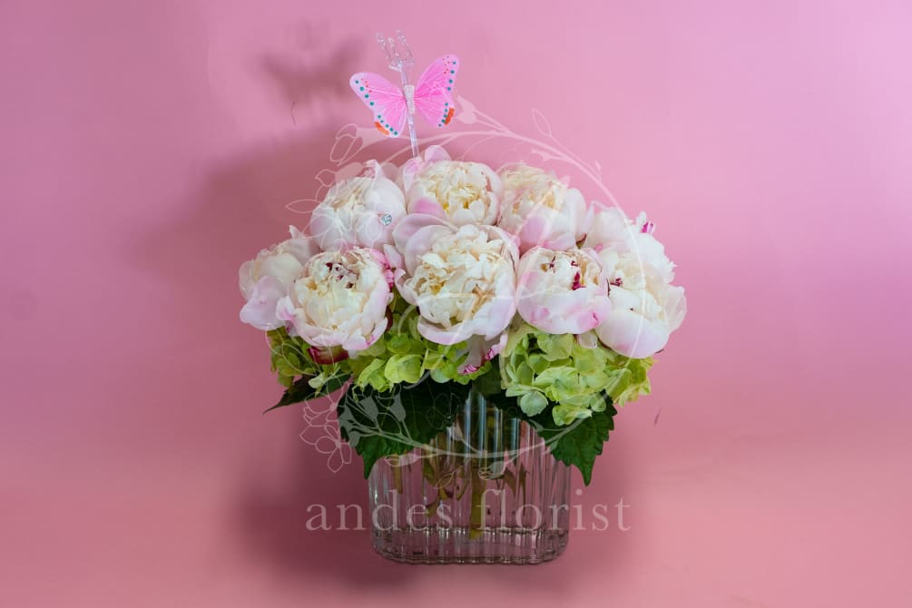 An abundance of peonies softly designed on a pillow of hydrangeas. If