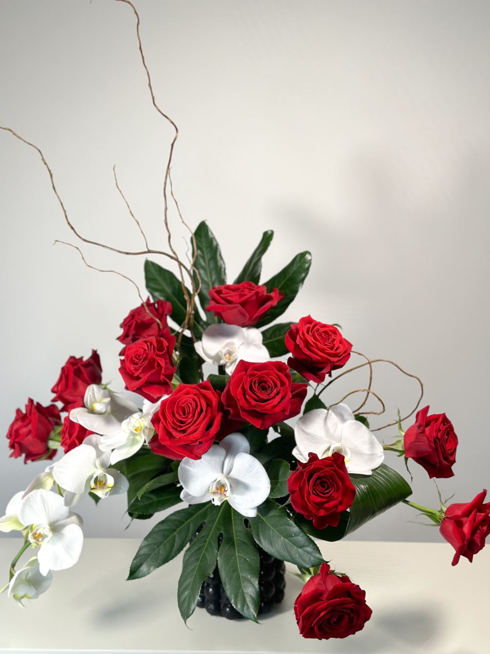 The arrangement of 18 stems of Red Ecuadorian Roses and White Phalaonapsis