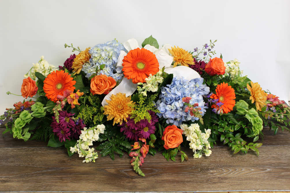 We use a garden mix of flowers to fill this casket spray