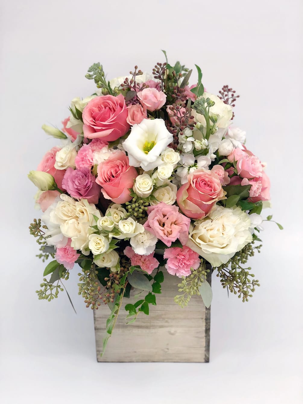 Flower box arrangement with mixed flowers in pink and white flowers.