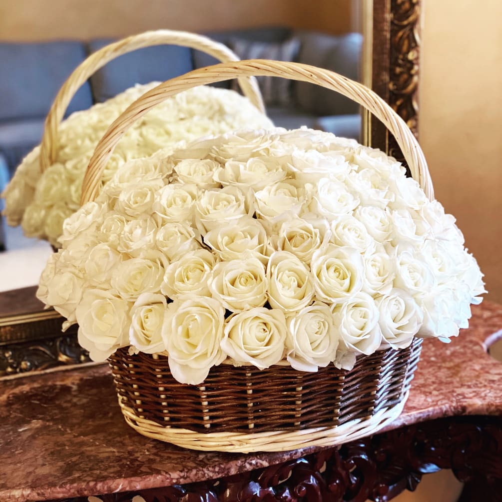 One hundred roses arranged in a basket. 
