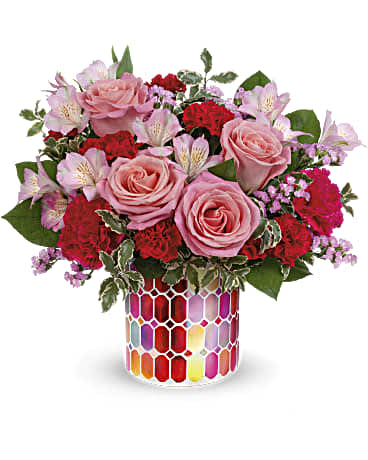 Pink roses, carnations, alstroemerias in a mosaic container. 
