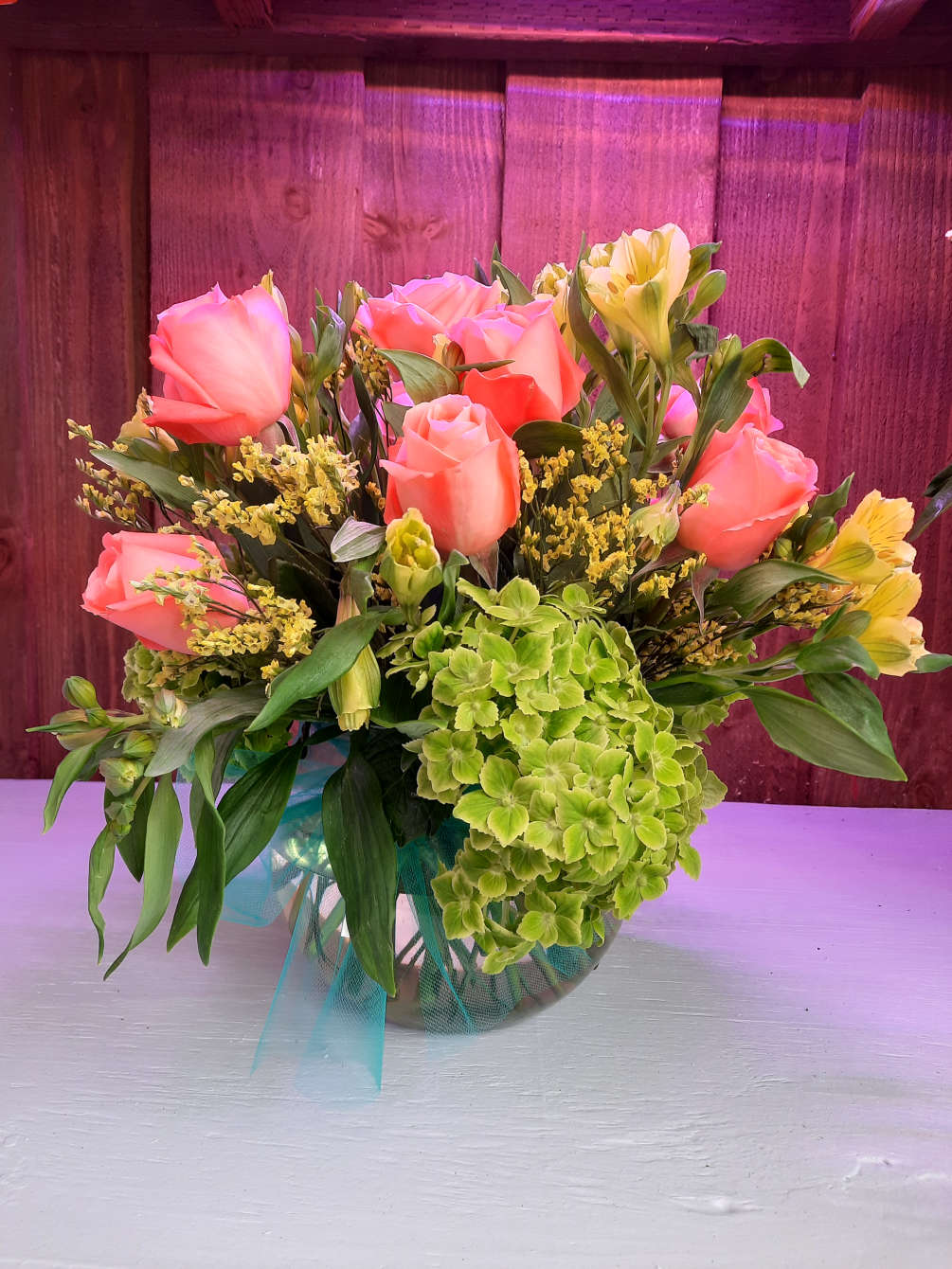 Peach Roses, Green, Yellow Alstromerias with filler arranged in a bubble clear