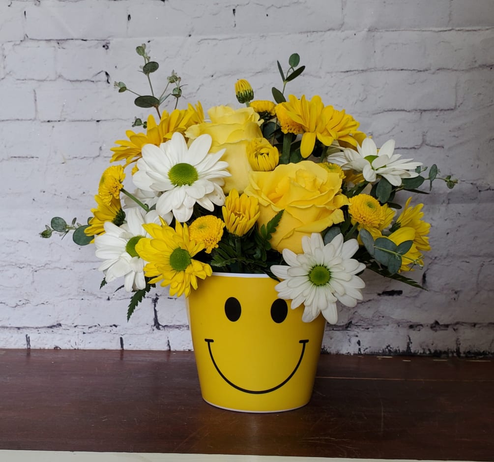 Happy Face Container with yellow and white daisies and 2 yellow roses.