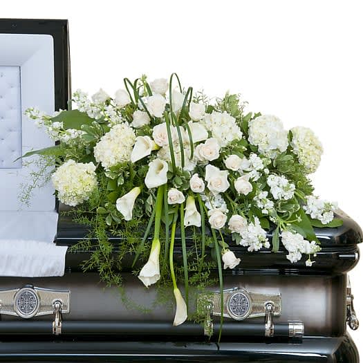 A elegant casket spray of premium white flowers beautiful spread to across.