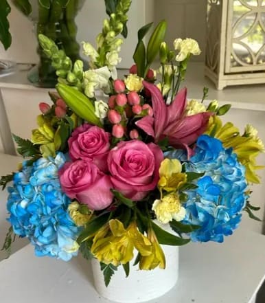 he bouquet is anchored by bold, blue hydrangeas, which provide a rich