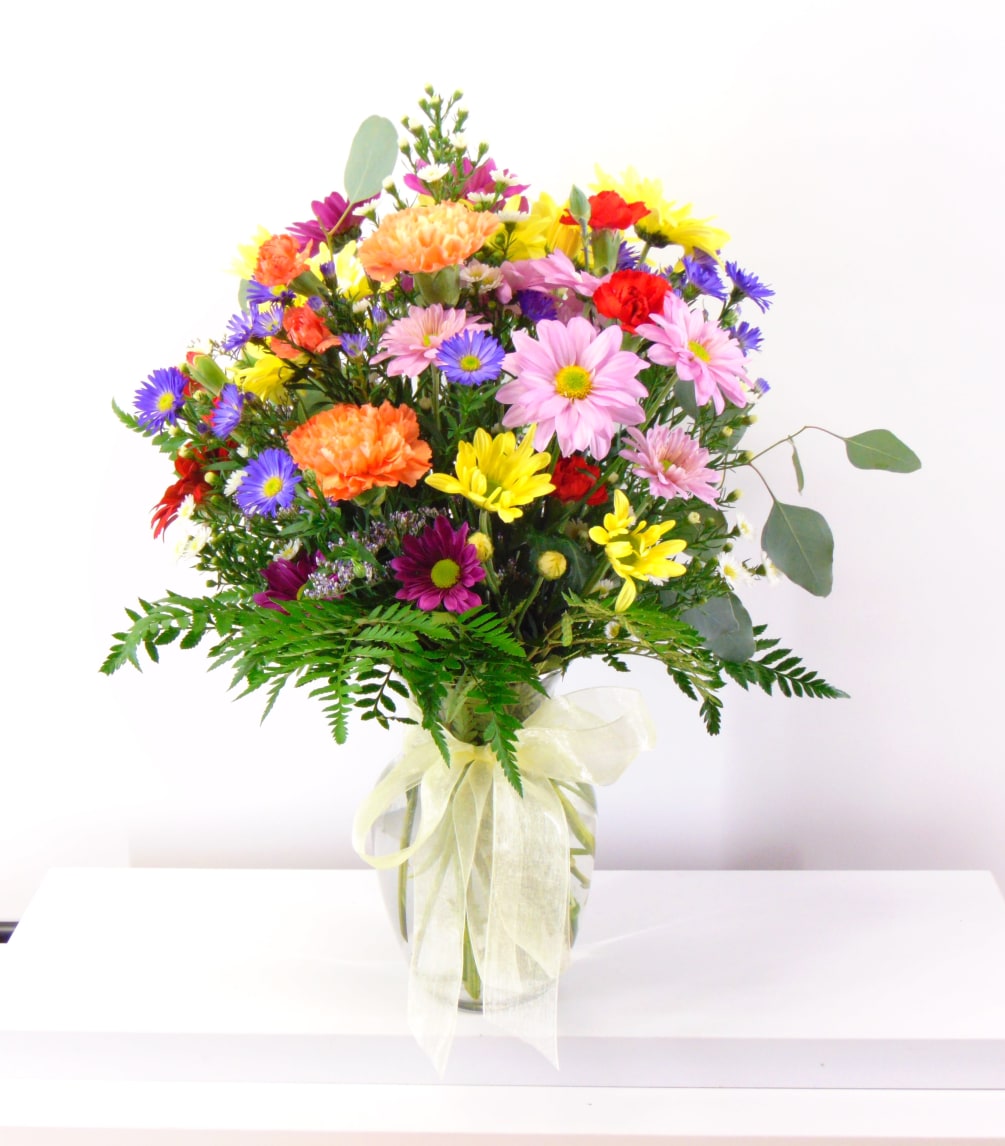  A mixed all-around arrangement bursting with coloful daisies, carnations, asters and