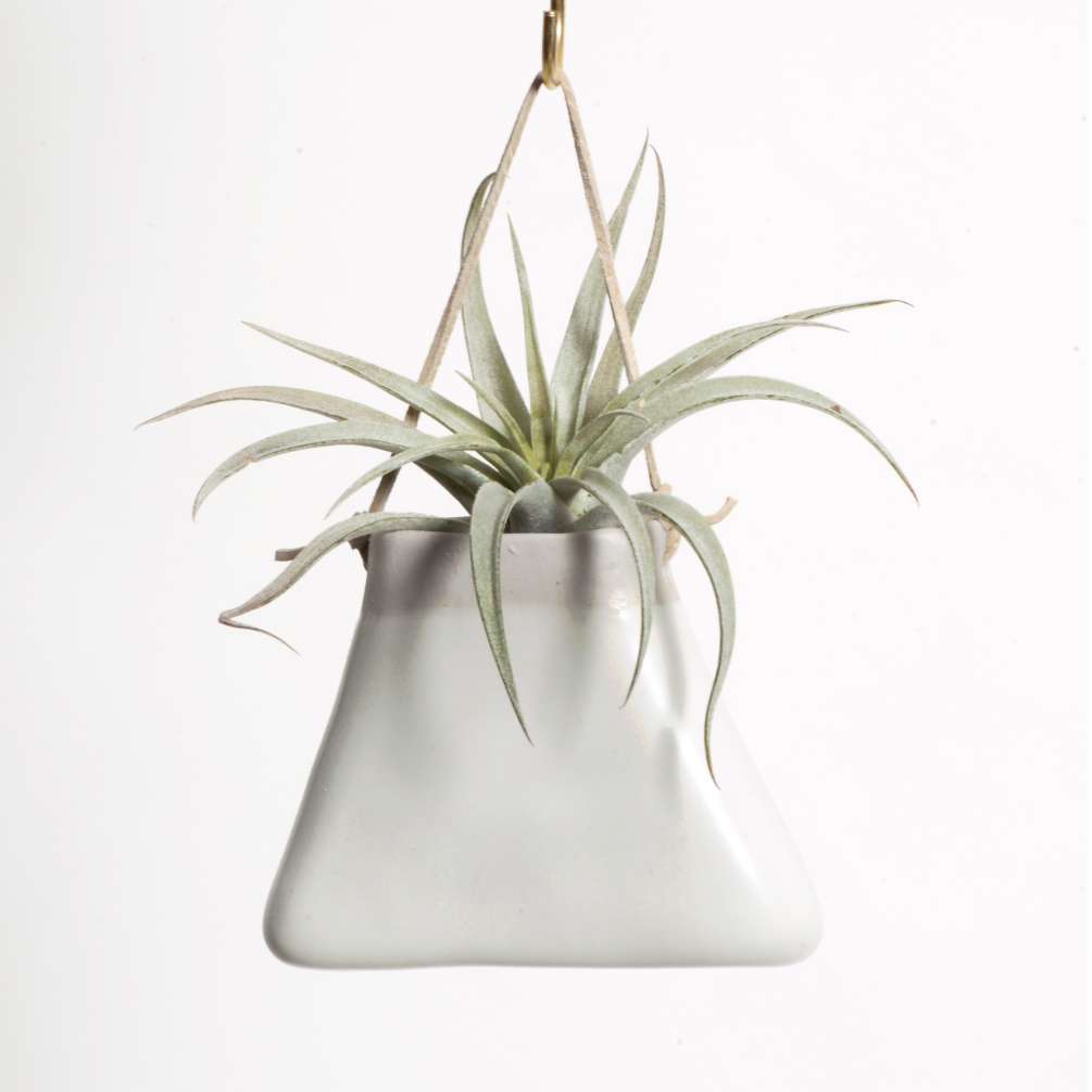 A ceramic triangular &quot;purse&quot; planter with matte white glaze with a tan