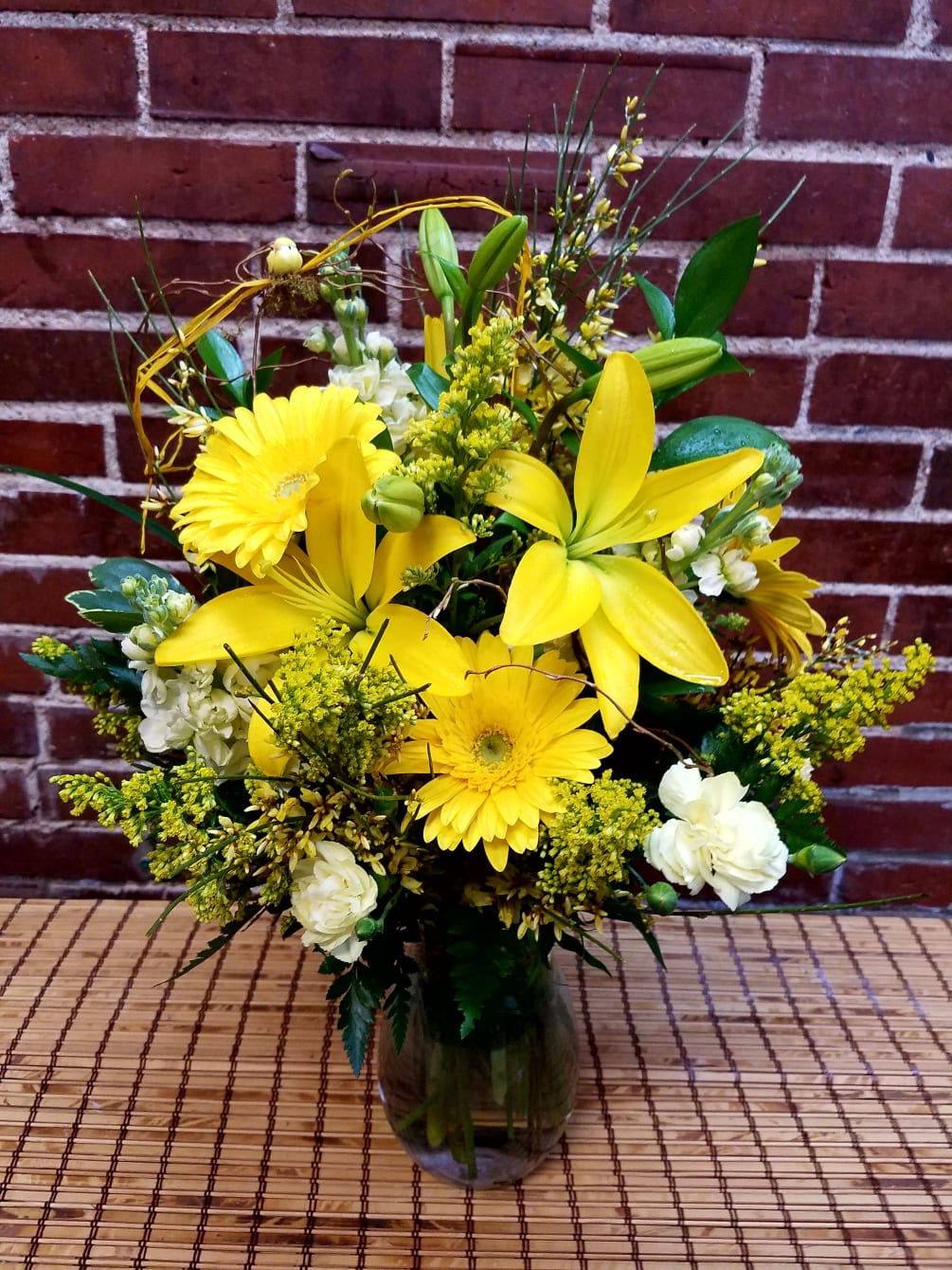 This gorgeous arrangement consists of yellow lilies, gerbera daisies, stock,  and